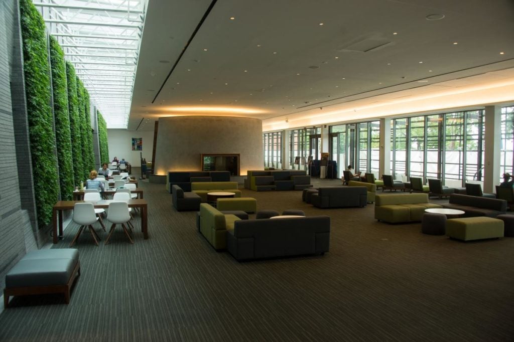 view of the Healy Family Student Center showing worktables, fireplace and open window areas.