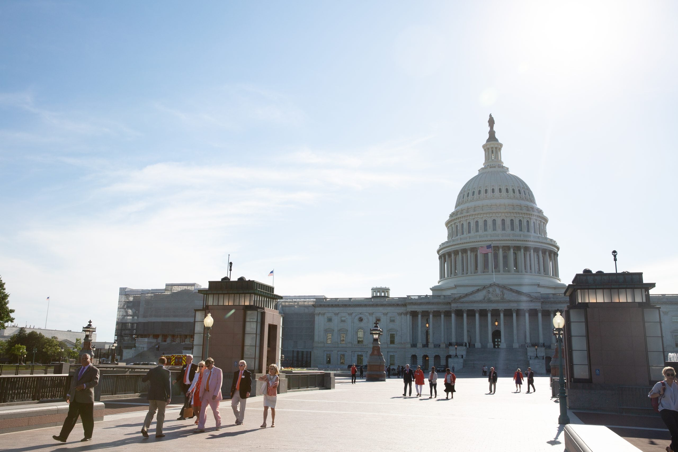 A small crowd walks outside of the Capitol Building