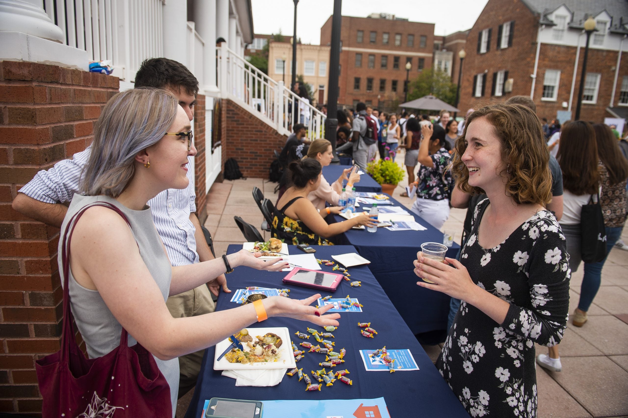 Two students interact at a table of pamphlets.