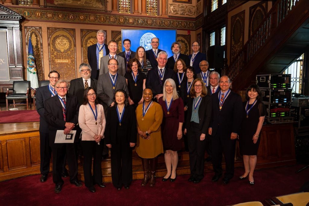 Faculty standing for a group photo inside Gaston Hall