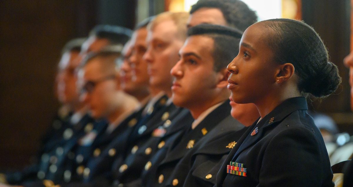 ROTC students sit in uniform inside Gaston Hall