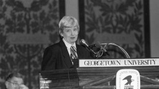 Professor Dorothy Brown speaks behind a podium in historic Gaston Hall