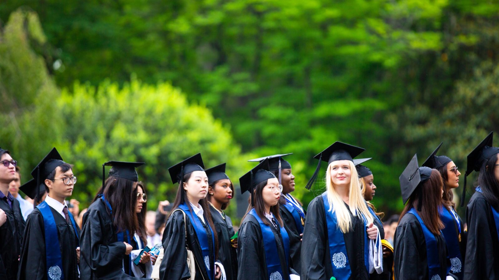 Graduate students wearing academic regalia line up on Healy Lawn for the Commencement Ceremony in 2019