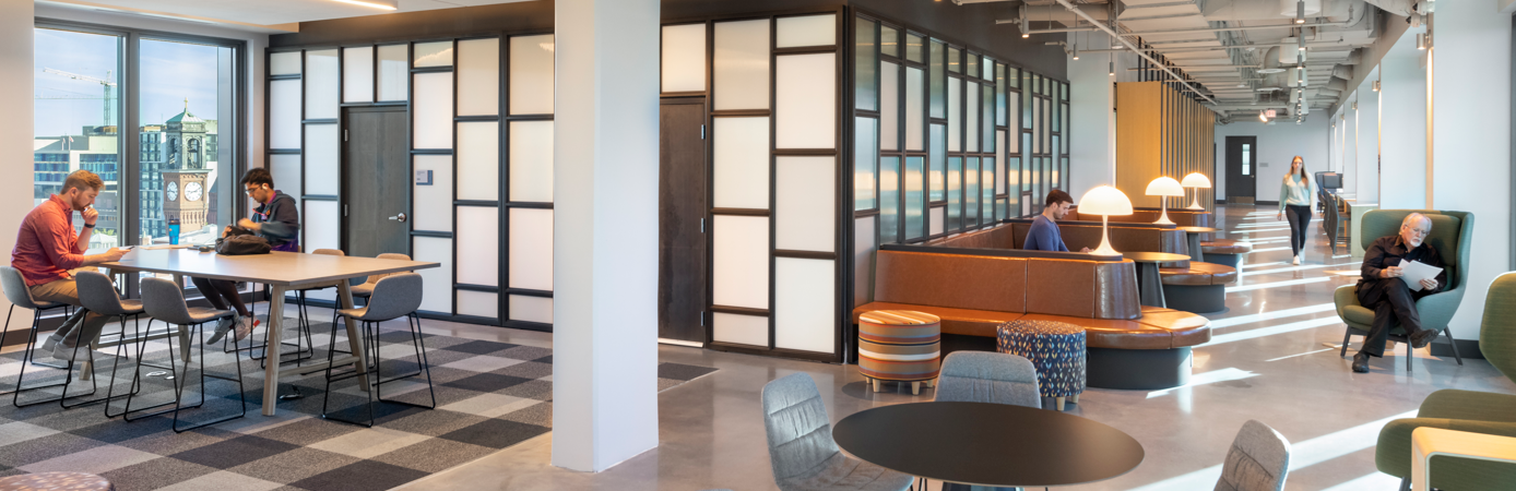 Grad and undergrad students sit at tables and booths studying in the penthouse at the Capitol Campus residence at 55 H St. NW