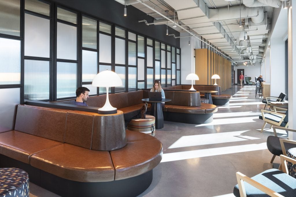 Graduate students study in the penthouse lounge at 55 H St. NW on leather sofas