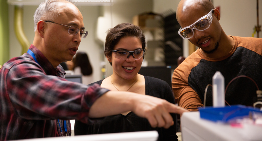 Professor YuYe helping two students