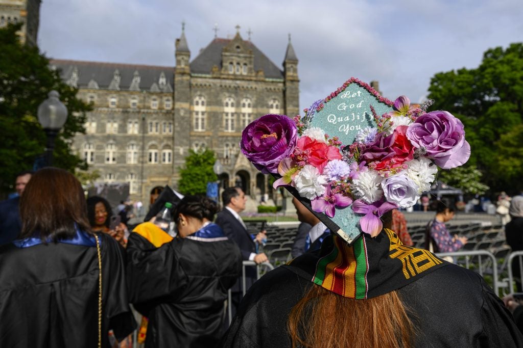 A graduate student shows off their ornately decorated cap at the Graduate School Commencement Ceremony in 2023