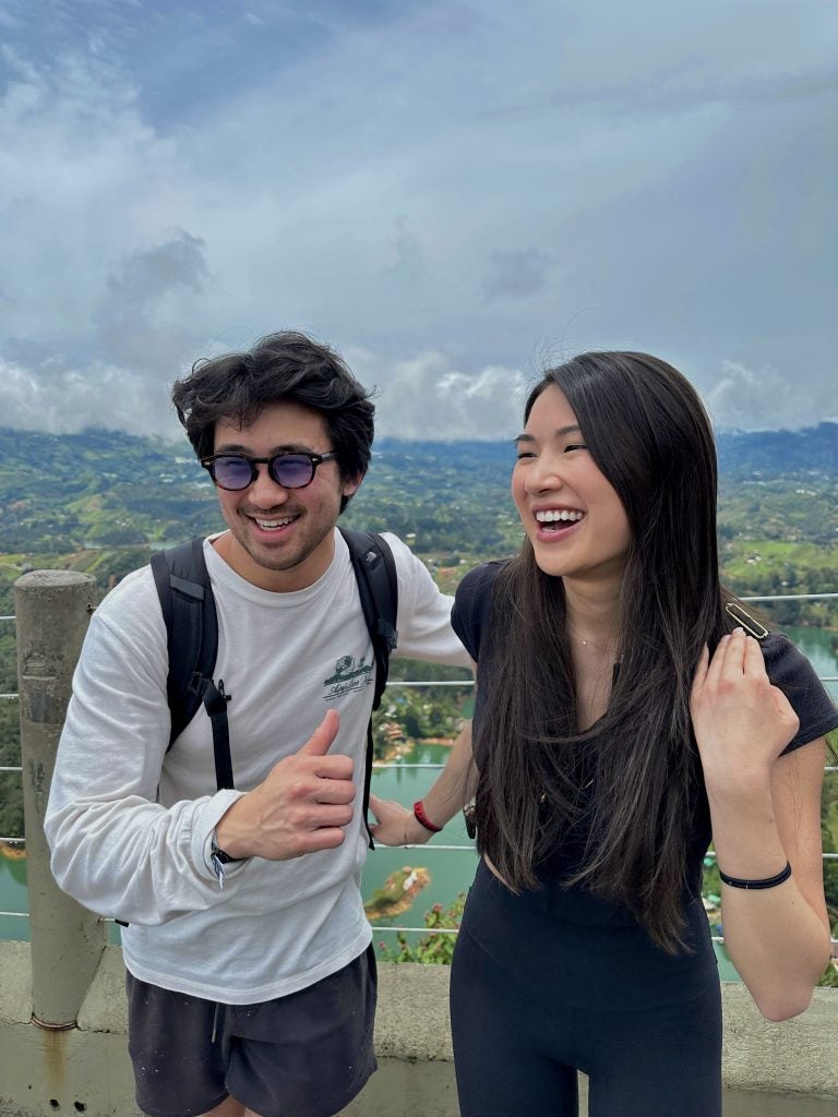 Ken Hoang and Kenzie Lau-Kee smile and laugh as they are on a trip together