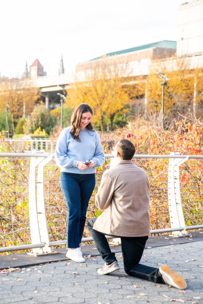 Nick DeMayo kneels in front of Gabby Deutsch to propose at the Georgetown Waterfront in fall