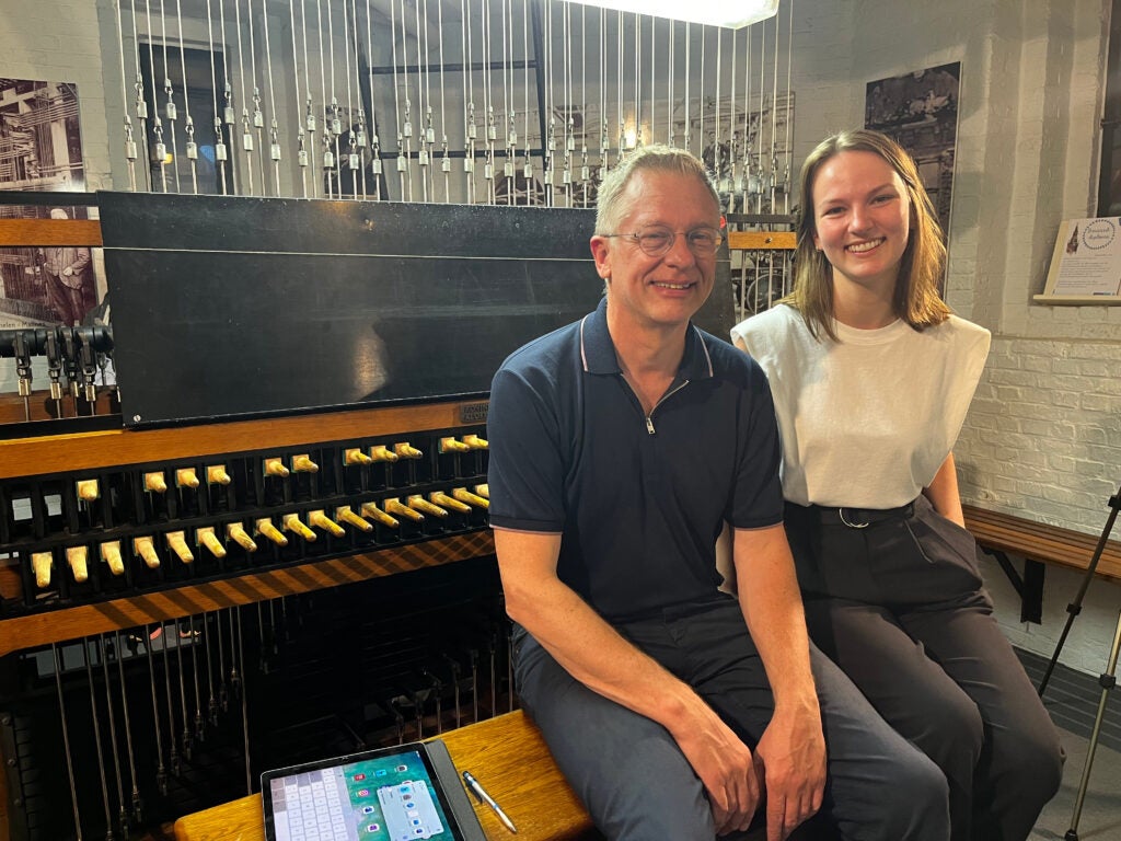 Cynthia Fioriti sits on a bench with carillon player in Belgium