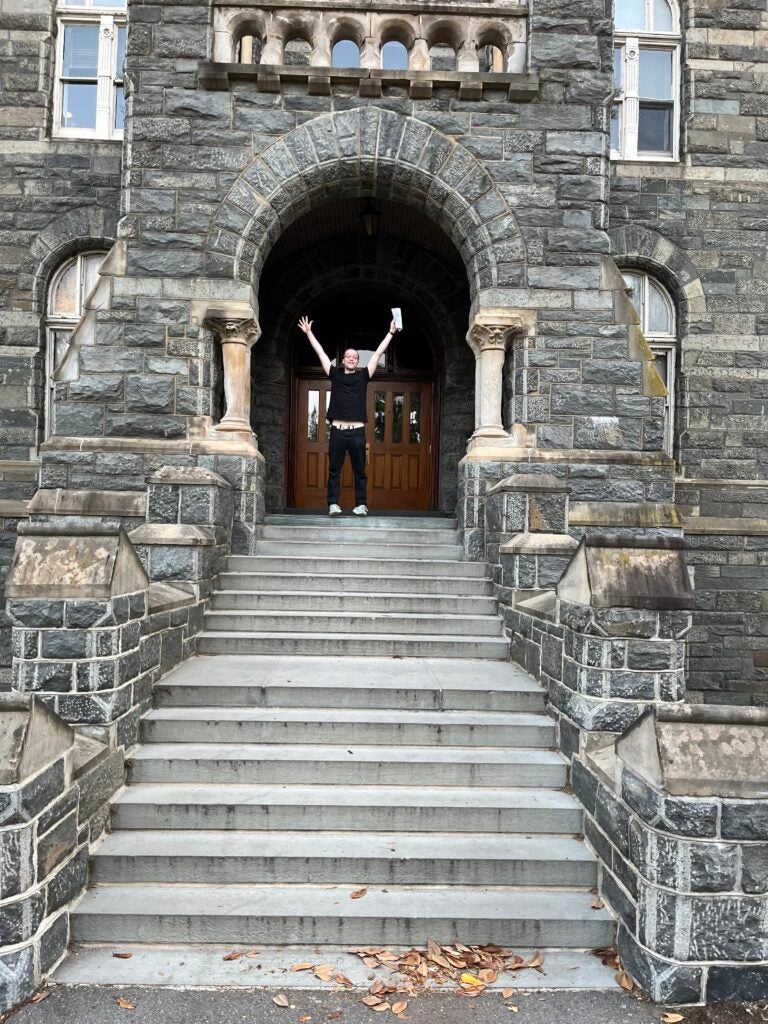 Jackson Wolf jumps as he stands in front of the entrance to Healy Hall building at Georgetown