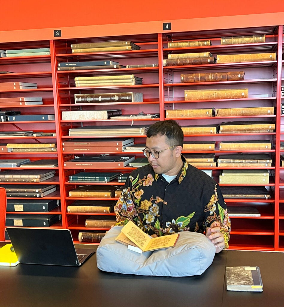 Khoiri at University of Leiden library reading a manuscript