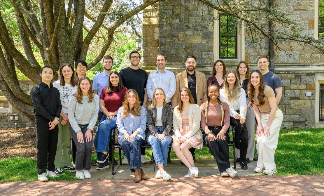 Psychology graduate students sitting and standing outside White-Gravenor Hall at Georgetown University