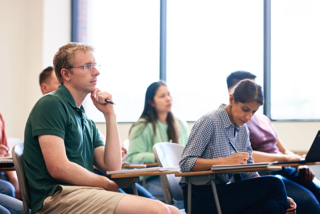 Students sitting at desks inside a Georgetown University classroom in a small group discussion