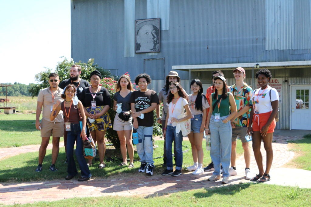 Grey (center, holding blue water bottle) stands in front of the Emmett Till Center with his peers