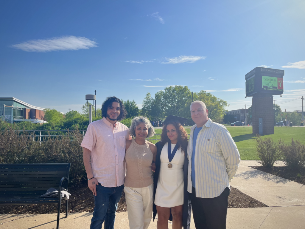 Lugo poses with her mon, dad and brother at Bryce Jordan Center at Penn State University after her graduation ceremony (May 2024)