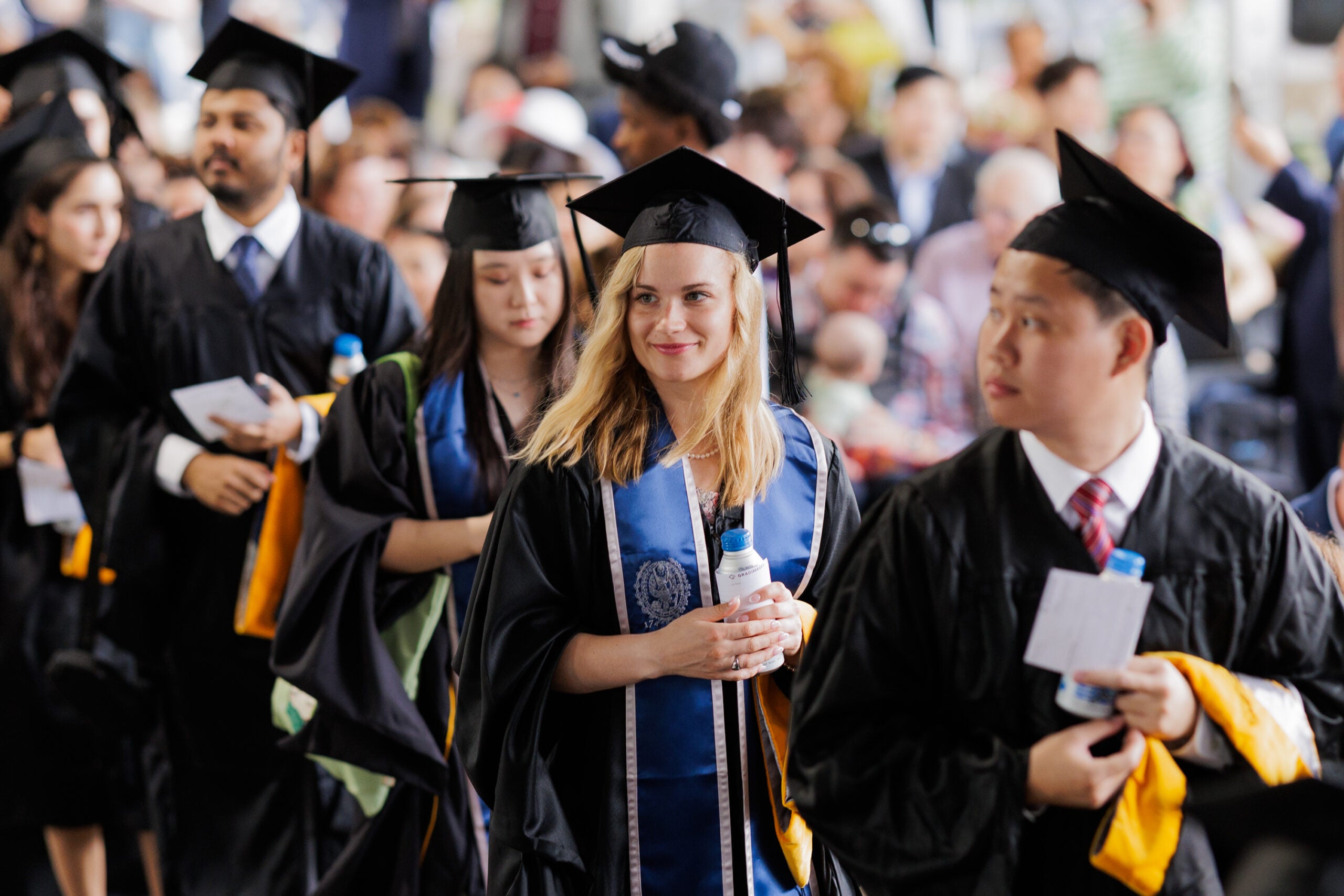 Students smile as they line up to take their seats at Commencement 2025.