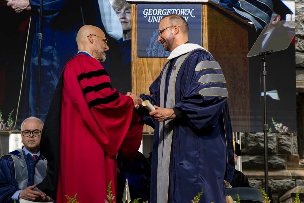 Rev. Arriaga shakes the hand of Graduate School Dean Alexander Sens.