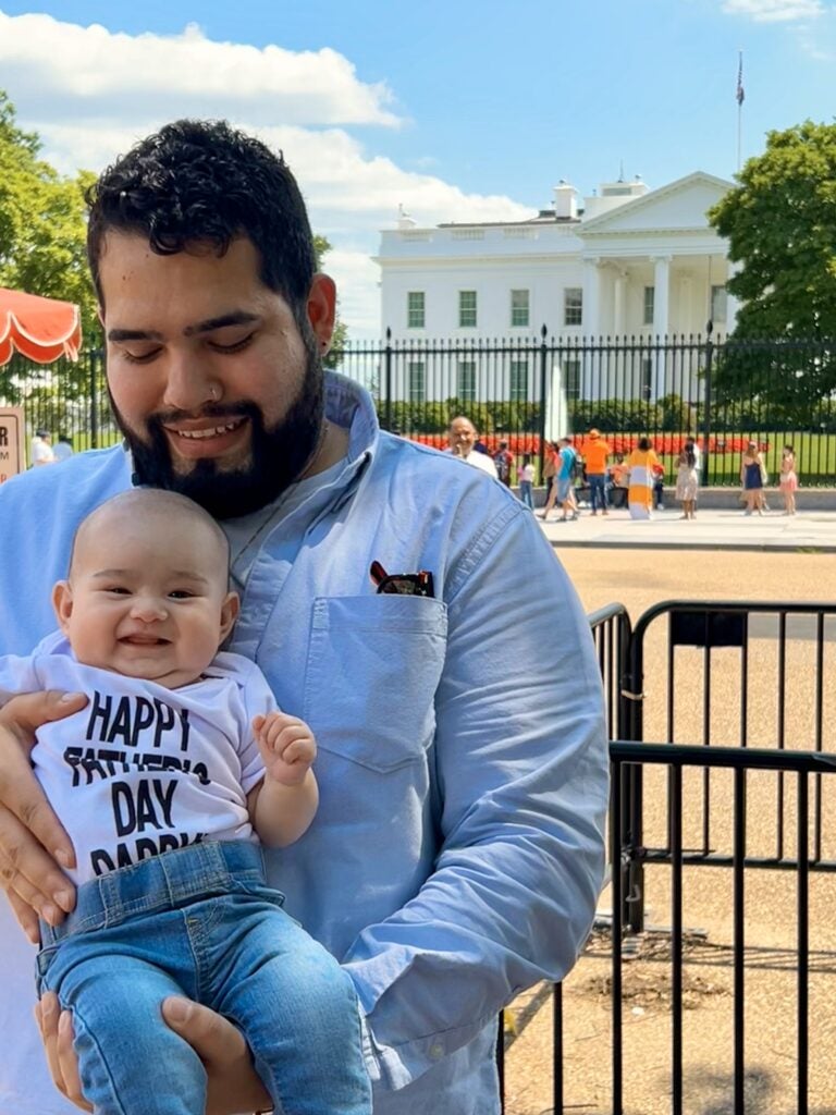Jauregui holds his infant daughter in front of the White House.