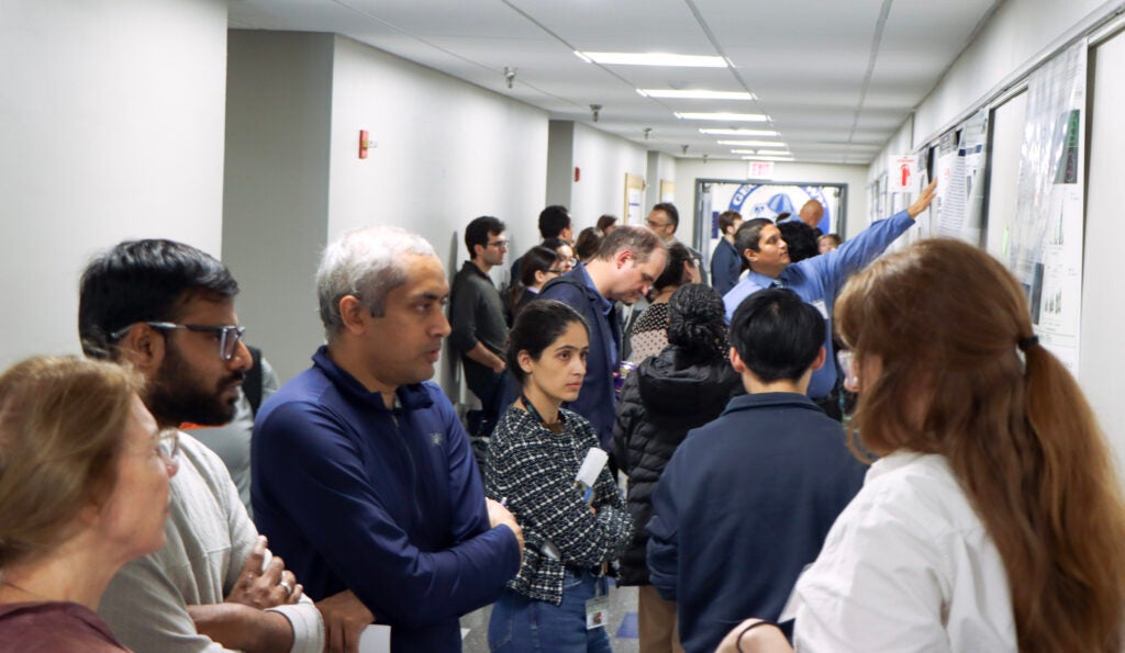 Attendees gather in a hallway of the Preclinical Science Building for the poster presentation at Student Research Day.