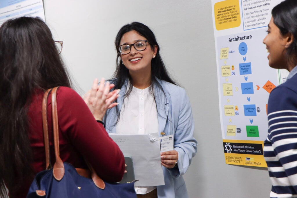 Amina Shorish smiles while talking with attendees at Student Research Day.