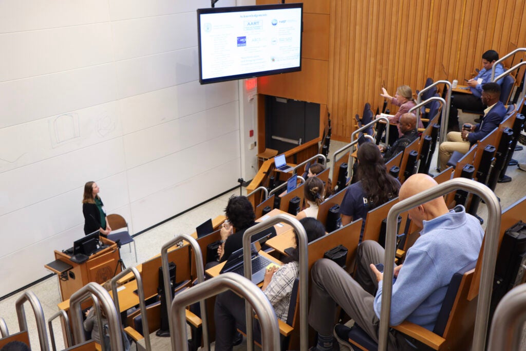 An auditorium full of students, faculty and staff listens as Micaila Curtis delivers an oral presentation at Student Research Day.