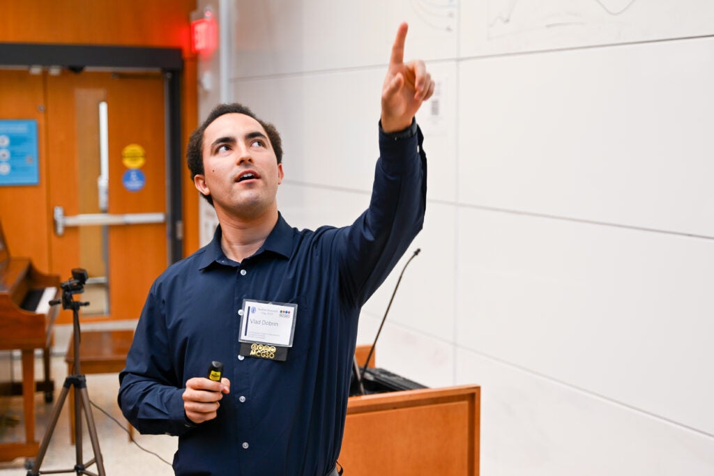 Vlad Dobrin points to his presentation while presenting at Student Research Day 2025.