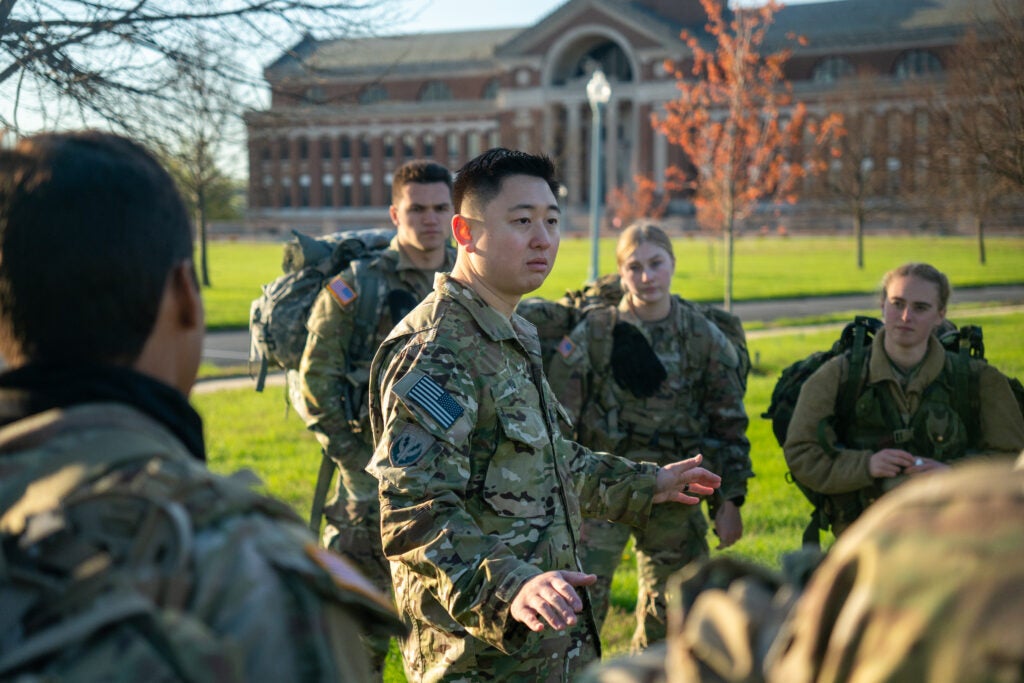 Xu Feng "Mike" Yu stands in the center of a circle of students in Army fatigues.