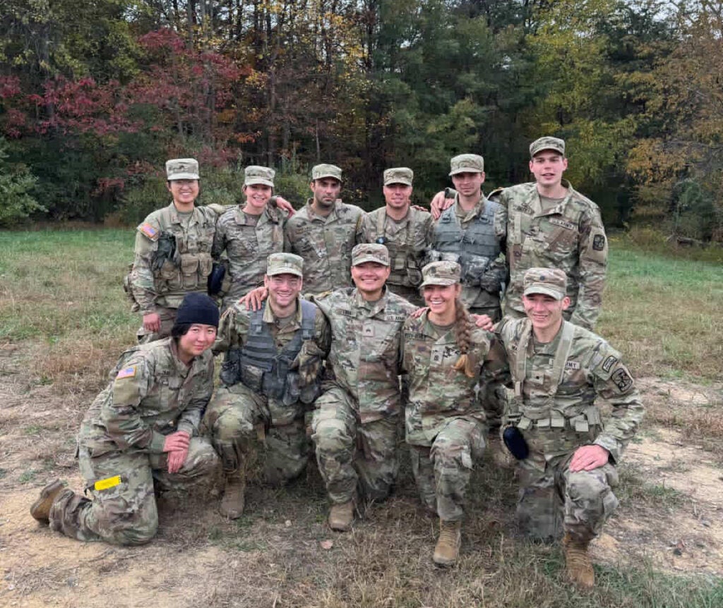 Rachel Jin poses in a group of 11 soldiers in Army fatigues.