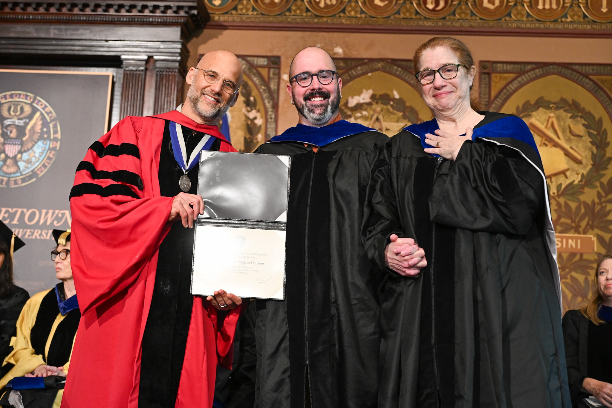 Dr. Vaughn Shirey receives the Harold N. Glassman Distinguished Dissertation Award from Dr. Alex Sens as his mentor, Dr. Leslie Ries, looks on.