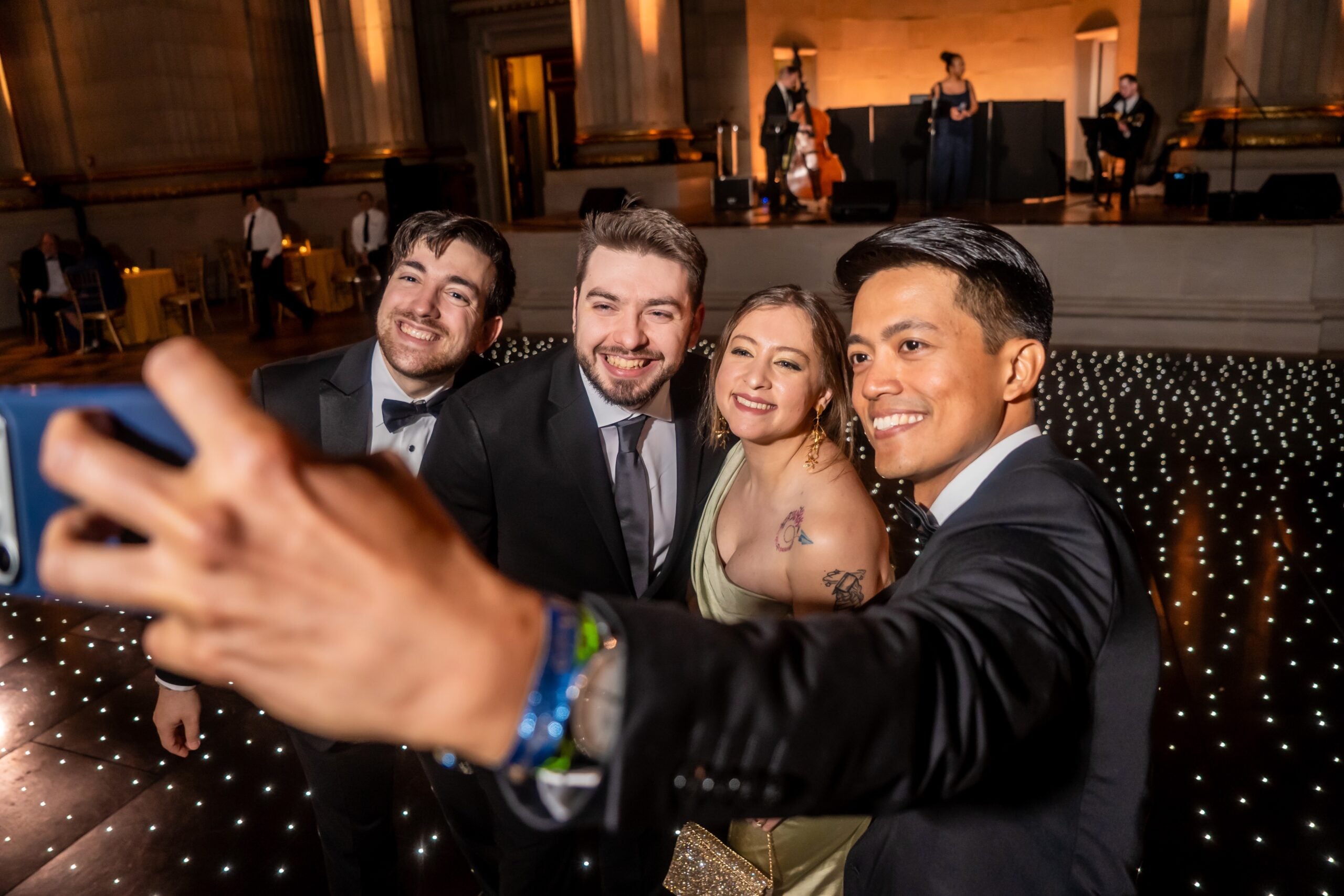 A group of four graduate students take a selfie with a cell phone at the 2026 Grad Gala.