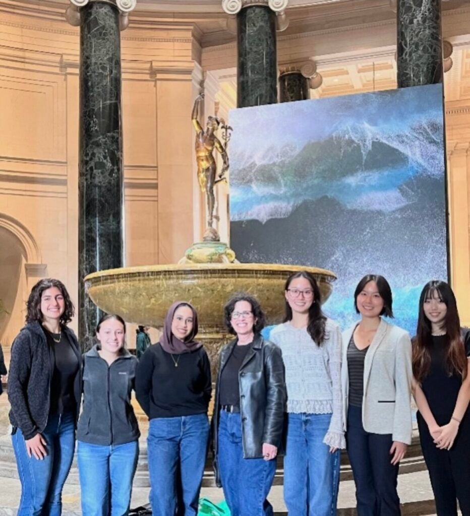 Seyoung Kim poses with a group of classmates in front of an indoor fountain a the National Gallery of Art.