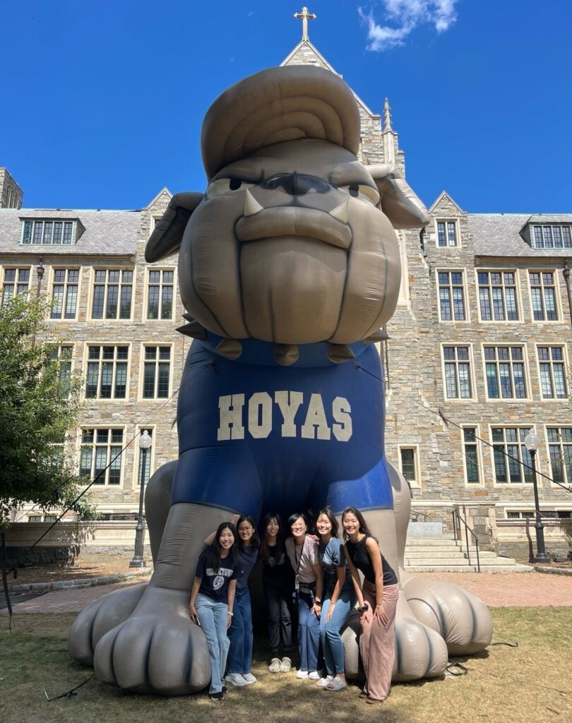Kim poses with a group of friends in front of an inflatable Jack the Bulldog.