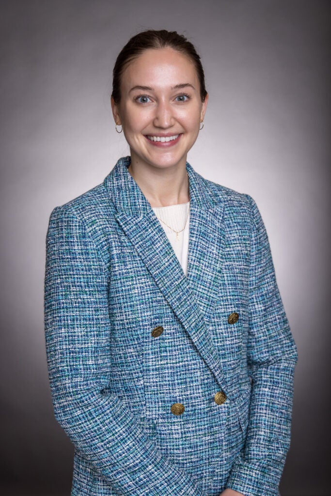A headshot of Anna Wright. Wright is wearing a blue suit.