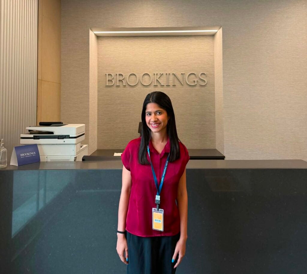Georgetown student Priyasha Chakravarti (C'25, G'27) poses in front of a sign reading "Brookings" in an office setting.