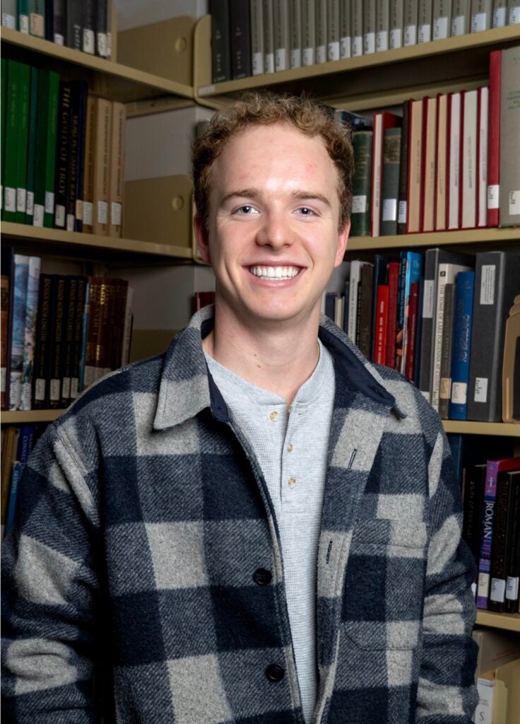 A headshot of Henry Schadwinkel in a library.