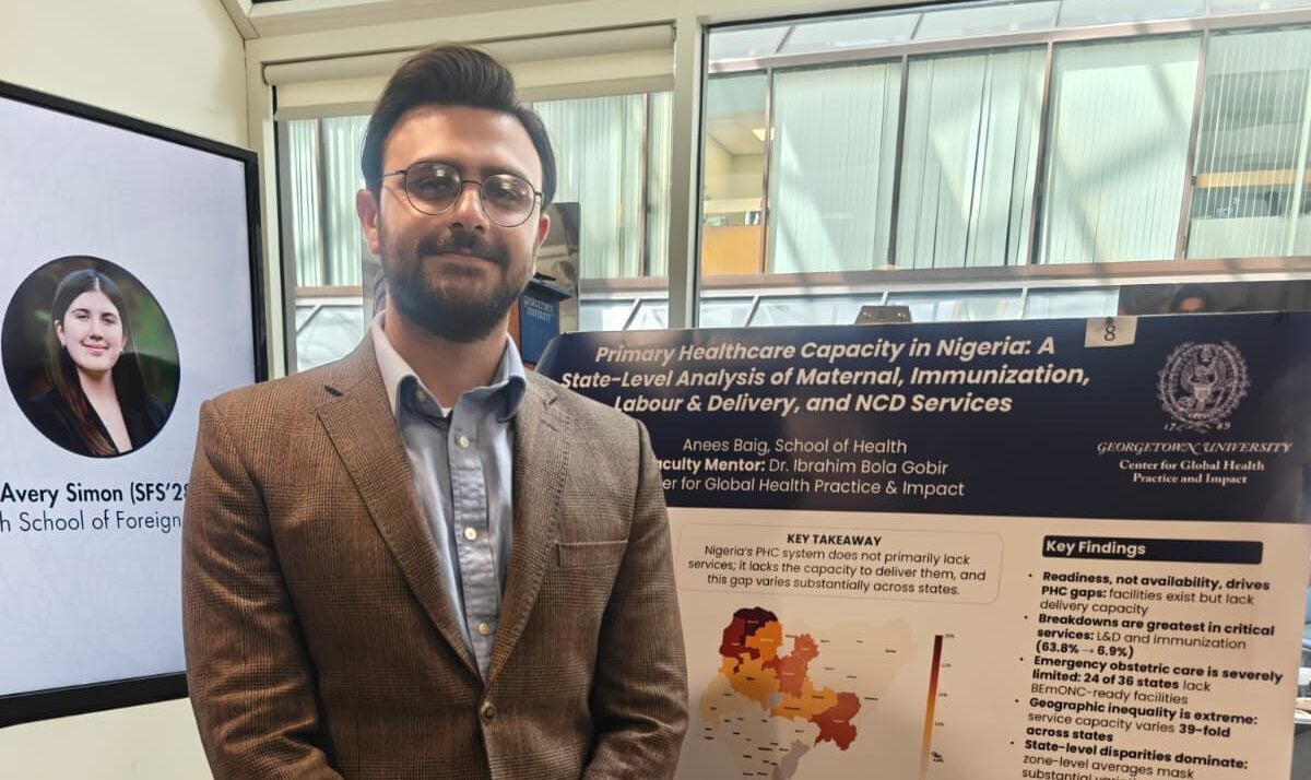 Anees Baig stands in front of his research poster during a showcase.