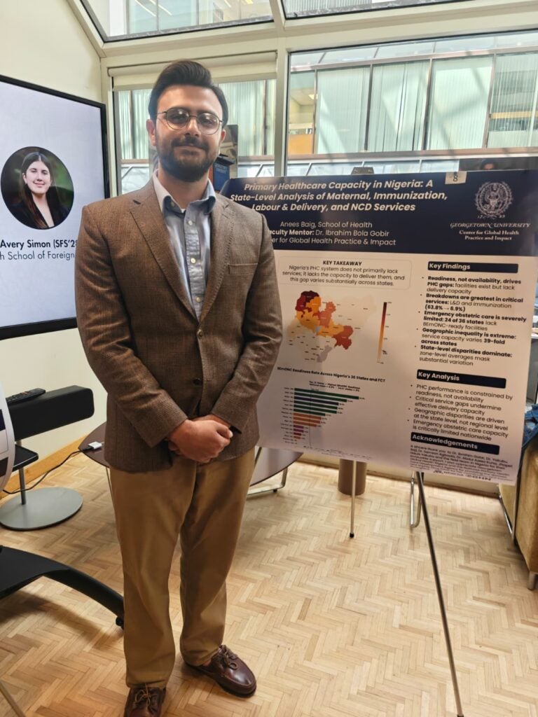 Anees Baig stands in front of his research poster.