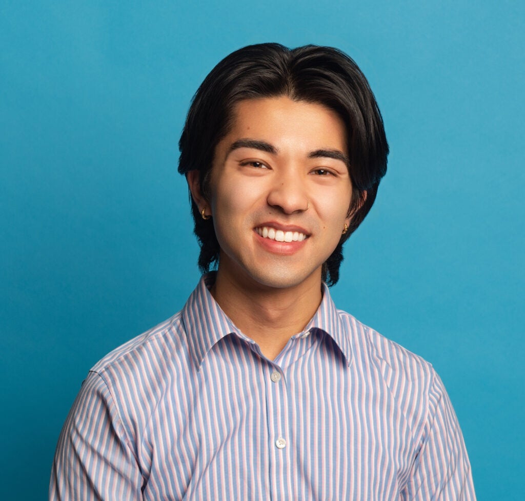 A headshot of Tyler Littlejohn against a blue background.